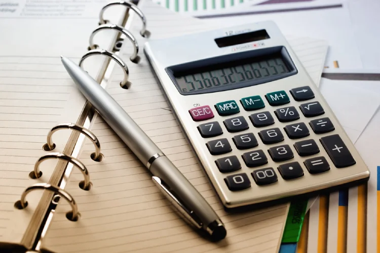 Calculator and pen on notebook—estimating Denver packing and moving costs for a local move.