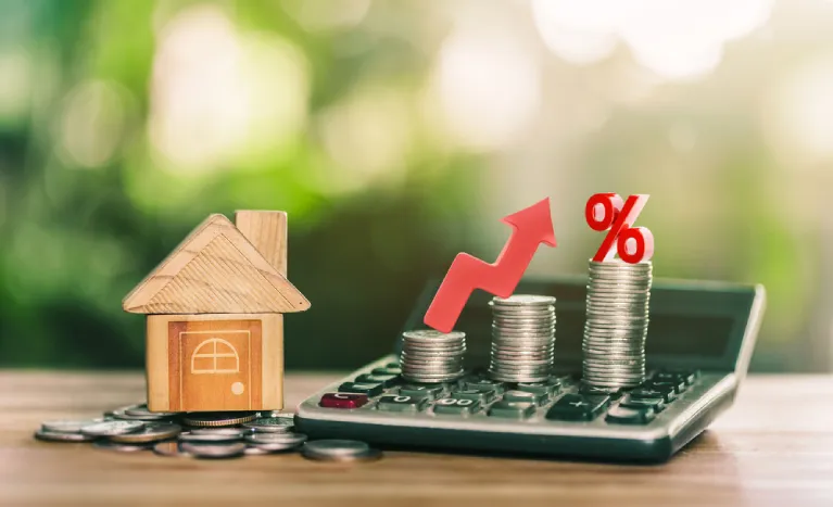 Stacked coins, a wooden house model, and rising percentages symbolizing Cherry Creek Denver housing costs.