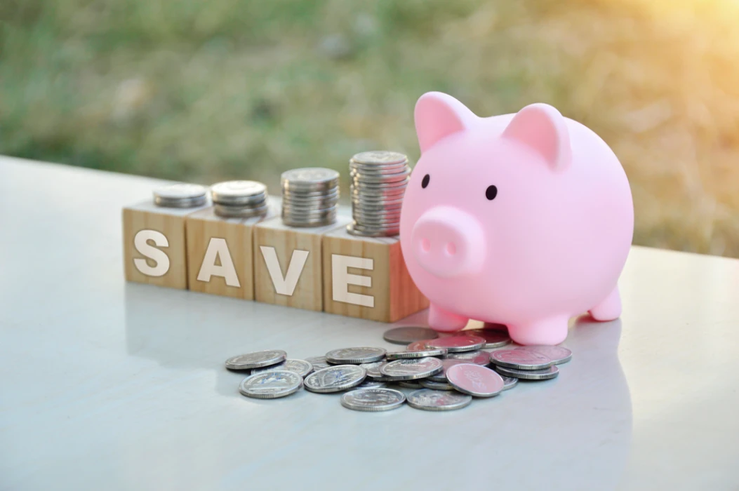 ink piggy bank beside stacked coins and wooden blocks spelling “save,” symbolizing cost-saving strategies for Denver local moves in 2025.