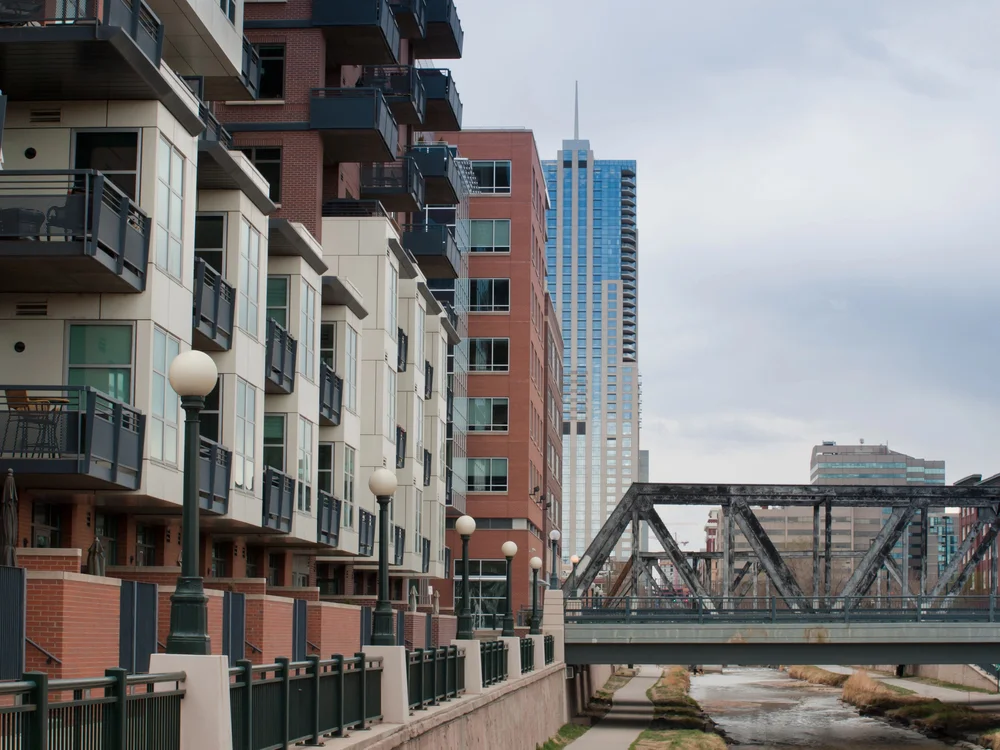 Modern apartments and high-rise buildings in Cherry Creek Denver with a city bridge view.