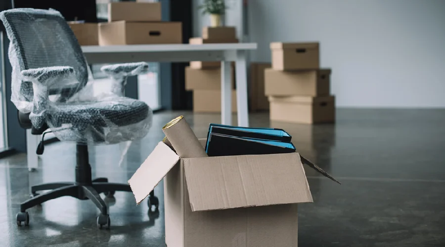 Bubble-wrapped office chair and moving boxes during a commercial office move in Lakewood, CO by Rocky Movers