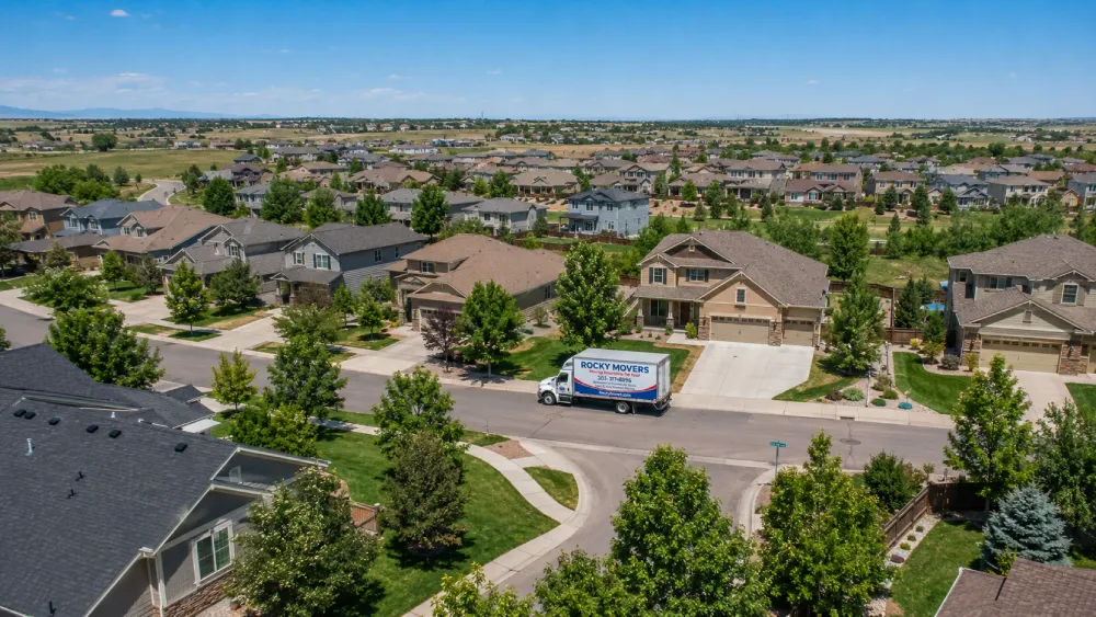 Aerial view of a Parker, CO master-planned neighborhood with a Rocky Movers truck parked on a residential street.